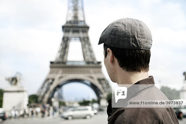 Junger Mann blickt auf den Eiffelturm  Paris  Frankreich  Europa