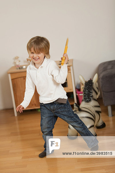 Kleiner Junge  3-jährig  spielt mit Schwert