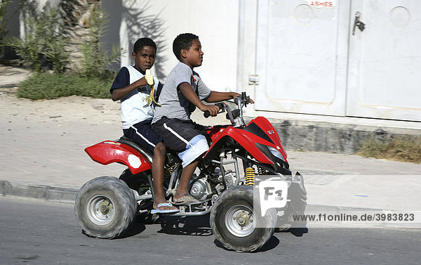Children on an all-terrain vehicle  Kingdom of Bahrain  Persian Gulf