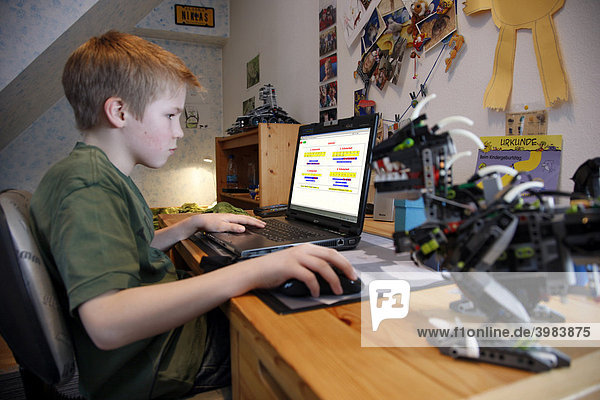Boy  11  working with his computer at home in his bedroom at a desk  learning for school using a mathematics learning programme