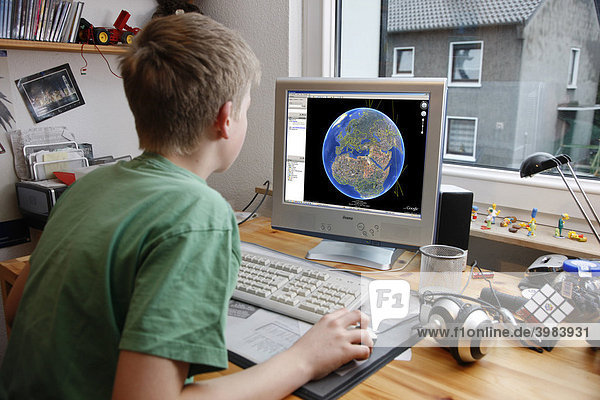 Junge  13 Jahre alt  arbeitet an seinem Computer zuhause  surft bei Google Earth