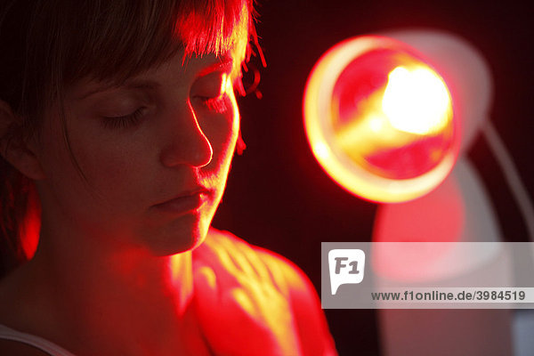 Young woman using a UV lamp  against a cold  tension  pain