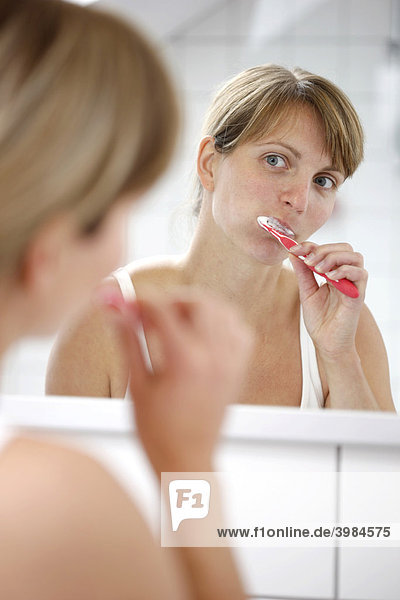 Young woman brushing her teeth in a bathroom