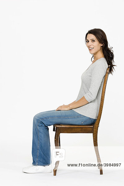 Frau sitzt auf Stuhl  richtige Körperhaltung zur Vorbeugung von Rückenbeschwerden