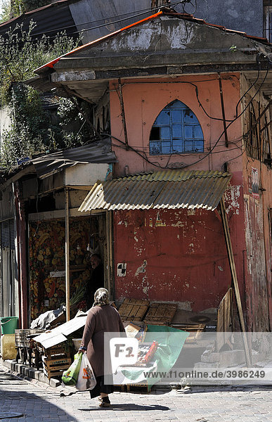 Frau mit Einkaufstüten geht vor kleinem Laden  pittoreske Straßenecke  altes  jüdisches Stadtviertel Balat  Istanbul  Türkei