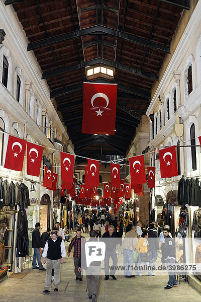 Überdachte Gasse mit Geschäften  viele Menschen unterwegs  aufgehängte Türkische Fahnen  Kapali Carsi  Großer Basar  Istanbul  Türkei