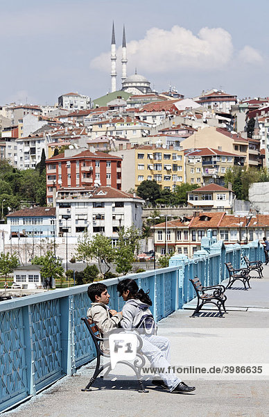 Junges türkisches Liebespärchen auf einer Bank  Panorama von Sütlüce mit Moschee  Goldenes Horn  Istanbul  Türkei