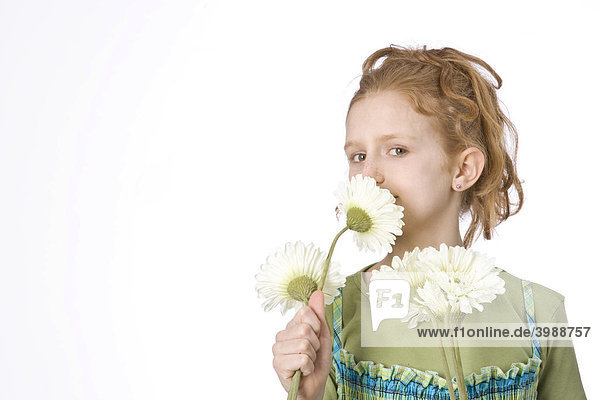 Rothaariges Mädchen riecht an Blumen