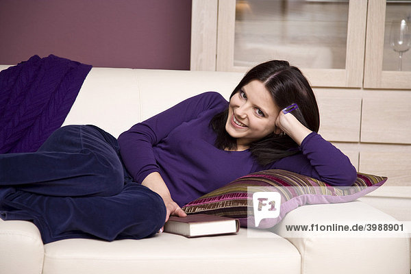 Girl lying in an armchair  cozy  with a book