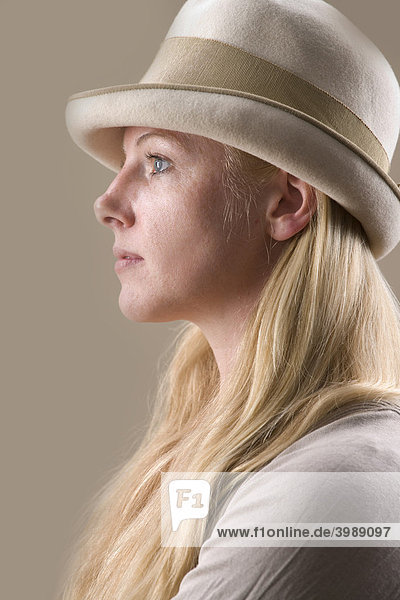 Junge blonde Frau mit Hut im Profil