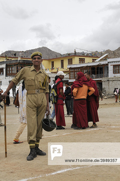 Indischer Soldat mit Schlagstock vor buddhistischen Mönchen  Leh  Ladakh  Nordindien  Himalaja