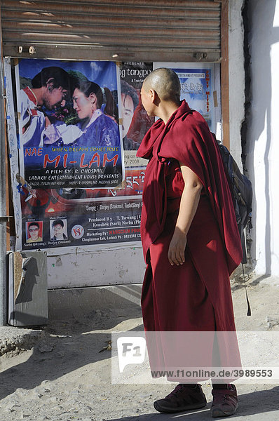 Buddhist monk looking at a modern cinema advertising in Leh  Ladakh  Northern India  India  Himalayas
