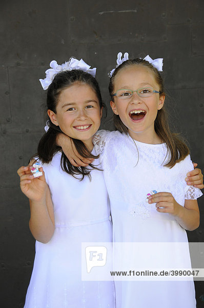 Glückliche Mädchen freuen sich über kleines Geschenk zur Erstkommunion