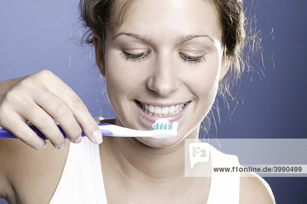 Junge Frau mit Zahnbürste und Zahnpasta