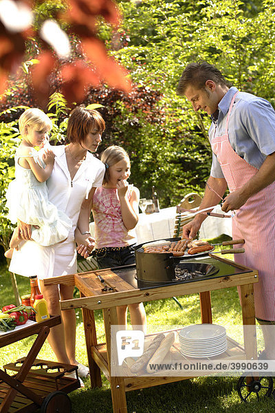 Familie beim Barbecue im Garten
