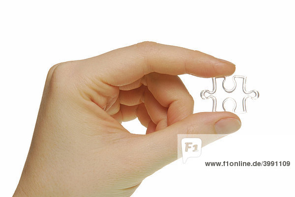 Frauenhand mit Puzzleteil  Symbolbild für Teil vom Ganzen