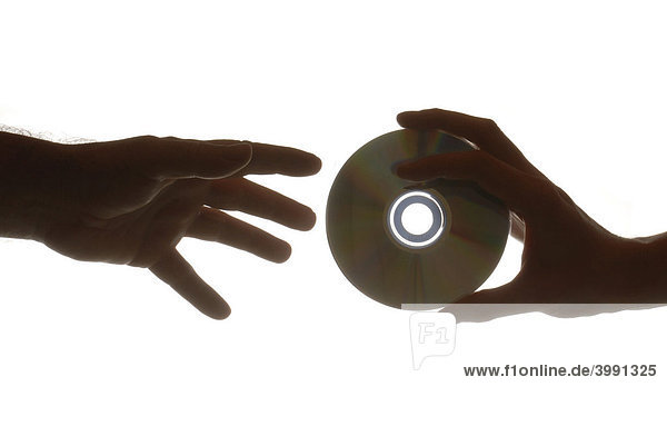 Frauenhand gibt CD an Männerhand  Symbolbild für Datenklau