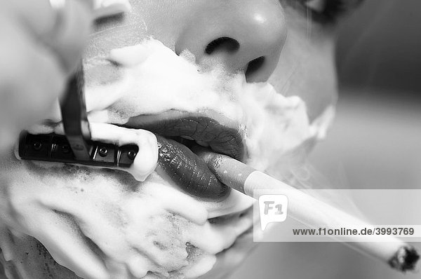 Detail einer Zigarette rauchenden Frau bei der Nassrasur mund