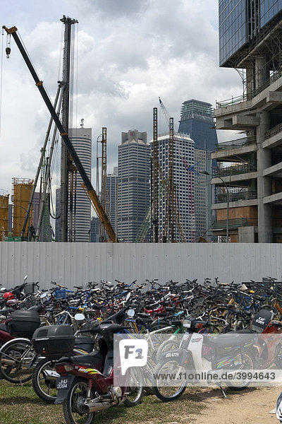 Fahrräder und Motorroller vor einer Baustelle  Bauboom  Singapur  Asien