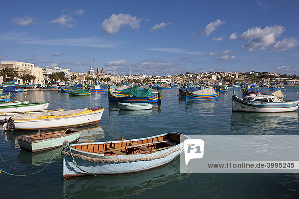 Traditionelle maltesisches Fischerboote im Hafen von Marsaxlokk  hinten die Kirche Lady of Pompei  Malta  Europa