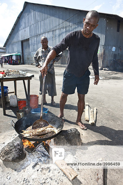 Ein Mann bereitet Fisch in einer Garküche zu  Stonetown  Stone Town  Sansibar  Tansania  Afrika