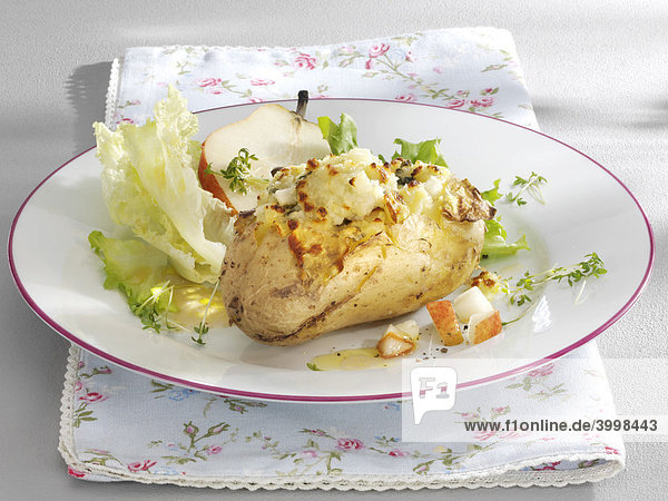 Gefüllte gratinierte Pellkartoffeln mit Birne  Salat auf Teller mit geblümter Serviette - Rezeptdatei vorhanden