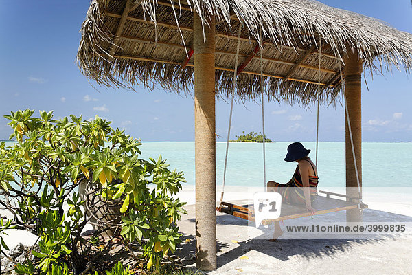 Frau mit Hut auf Schaukel mit Dach  Strand  Lagune  Meer  Malediveninsel  Rihiveli  Insel  Süd Male Atoll  Malediven  Archipel  Indischer Ozean  Asien