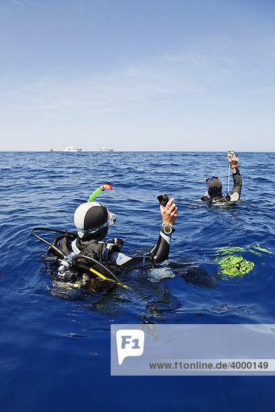 Abgetriebene Taucher auf dem Meer versuchen durch Blinken mit Spiegeln Aufmerksamkeit von Personen auf Tauchschiffen am Horizont zu erregen  Ägypten  Rotes Meer  Afrika