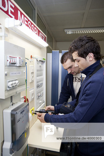 Master electrician students using a voltmeter on a VDE measuring station  control panel  fuse box  master electrician from the Master Craftman School of the Chamber of Small Industries and Skilled Trades  Dusseldorf  North Rhine-Westphalia  Germany  Europe