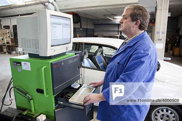 Master Craftsman of motor vehicle mechanics and lecturer of the Master Craftmans School of the Chamber of Small Industries and Skilled Trades performing a diagnostics test on a car  Dusseldorf  North Rhine-Westphalia  Germany  Europe