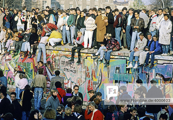 Menschen auf der Mauer am Brandenburger Tor  am Tag nach dem Mauerfall  Berlin  Deutschland  Europa