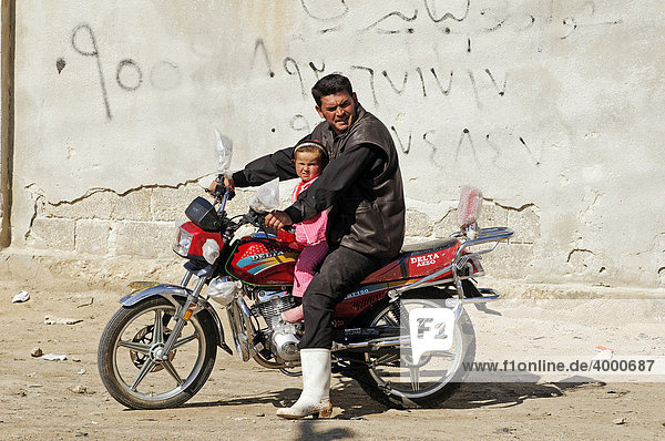 Mann mit Kind auf Motorrad bei Aleppo  Syrien  Asien