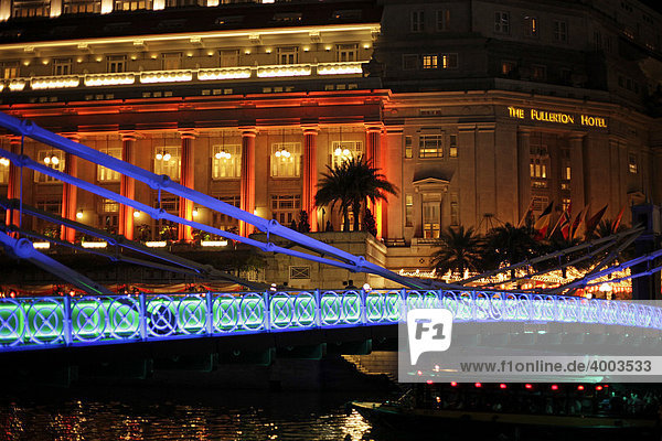 Colourfully lit bridge and Fullerton Hotel  Singapore  Asia