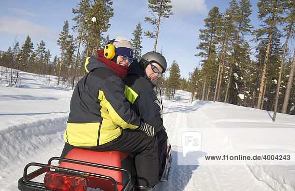 Man and woman  in their forties  on a snowmobile tour in Kiruna  Lappland  North Sweden  Sweden