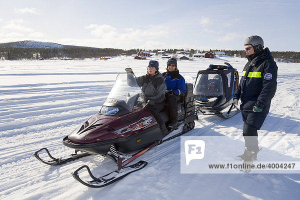 Two women and a man in their forties on a snowmobile tour in Kiruna  Lappland  North Sweden  Sweden