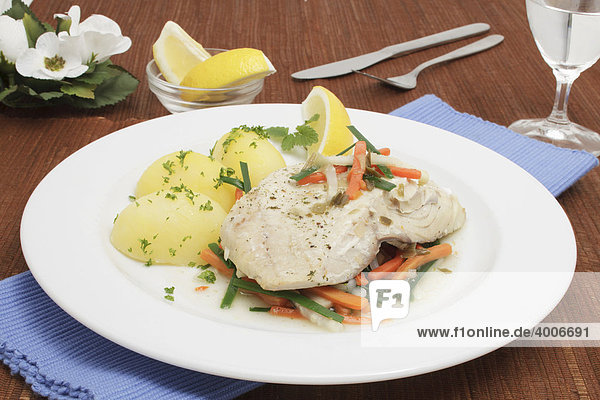 Steamed Saithe fillet on a bed of colourful vegetables with boiled potatoes