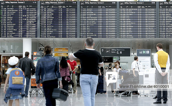 Passengers in front of the information board listing the departure times  Terminal 2 of Munich Airport  Franz-Josef-Strauss Airport  Munich  Bavaria  Germany  Europe
