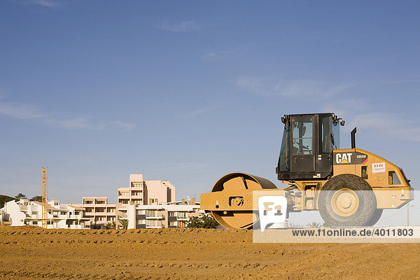 Bodenverdichter mit Glattbandage von Caterpillar vor einem Neubaugebiet in Lagos  Algarve  Portugal  Europa