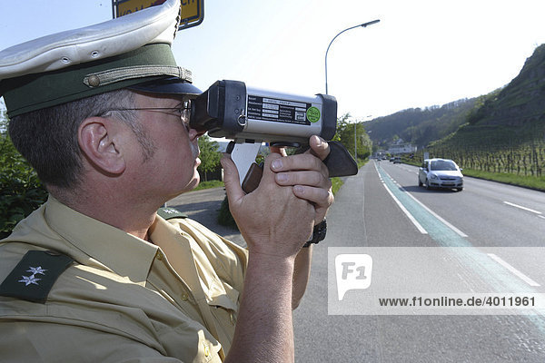 Ein Polizeibeamter bei der Geschwindigkeitskontrolle mit Hilfe einer Laserpistole  Koblenz  Rheinland-Pfalz  Deutschland  Europa