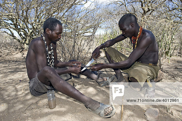Members of the Hadzabe tribe making a hunting arrow  Lake Eyasi  Tanzania  Africa