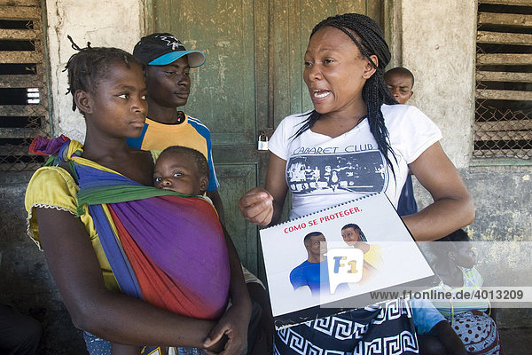 Anschauungsmaterial zum Schutz vor HIV AIDS wird einem jungen Paar mit Kind erläutert  Quelimane  Mosambik  Afrika