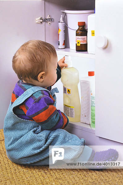 Kleinkind holt Reinigungsmittel aus einem nicht verschlossenen Schrank