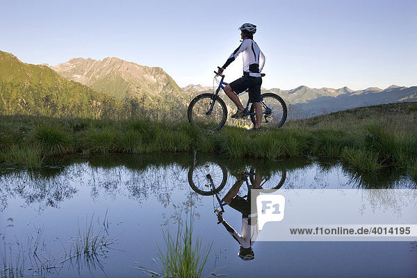 Mountainbiker on the shore of a mountain lake  Northern Tyrol  Austria  Europe