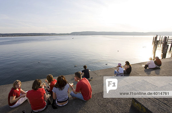 People sitting on the lakeside promenade  Lake Constance  Ueberlingen  Baden-Wuerttemberg  Germany  Europe