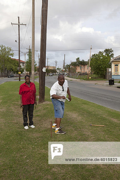 Ein Mann und eine Frau werfen beim Horseshoes-Spiel mit Hufeisen  Mittelstreifen der St. Claude Avenue  New Orleans  Louisiana  USA