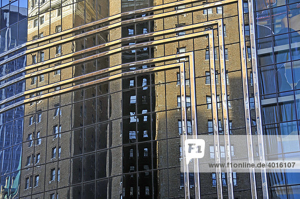 In der mondänen Glasfassade von einem neueren Bürohochhaus spiegelt sich ein älteres Mietshaus aus Backstein  Manhattan  New York City  USA