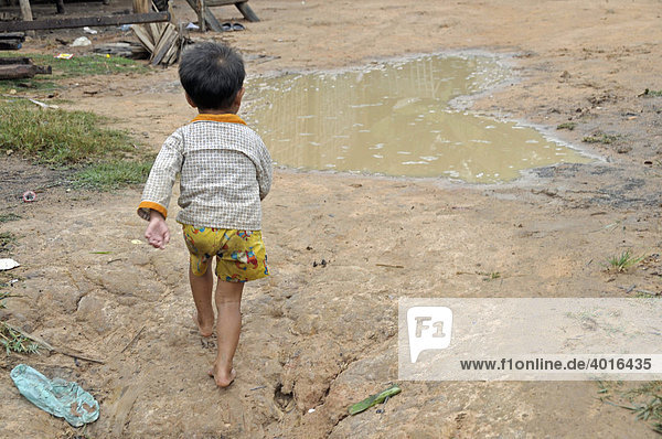 Little boy running through the slums of Siem Reap  Cambodia  Asia