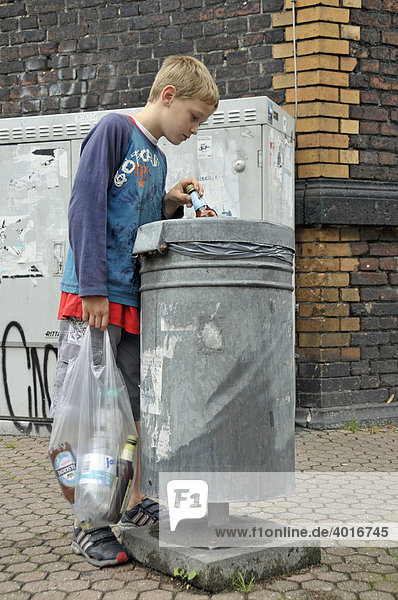 Ein neunjähriger Junge verdient sein Taschengeld durch Sammeln von Pfandflaschen  Deutschland  Europa