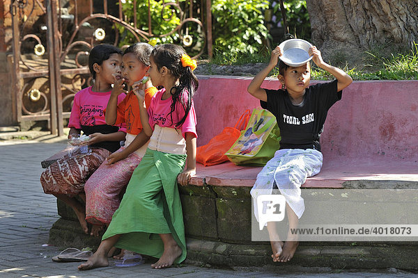 Four girls sitting on a bench  Ubud  Bali  Indonesia