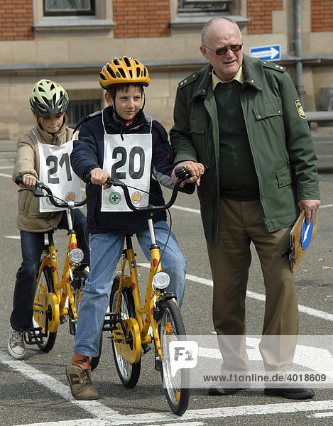 Verkehrsunterricht  Schulkinder  zehn Jahre alt  4.Klasse  auf Fahrrad neben Polizist